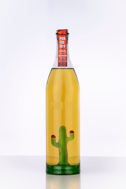 Tall clear Porfidio agave-spirit bottle with an internal green glass cactus, embossed front and long tapered shoulder on a white background.