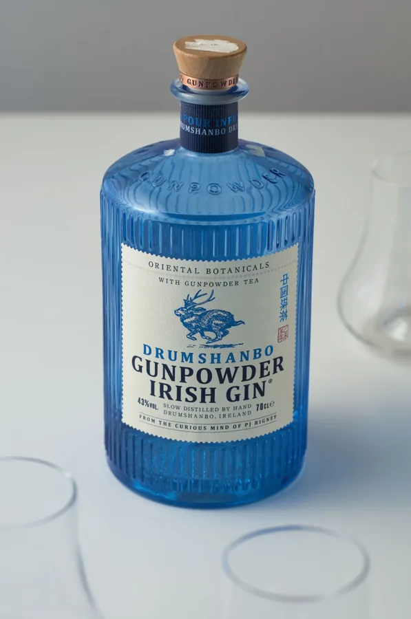 Blue Drumshanbo gin bottle with ribbed panels, embossed shoulder, broad circular body and wood stopper.